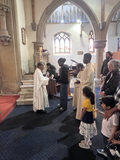 A child and family members near the priest during Communion