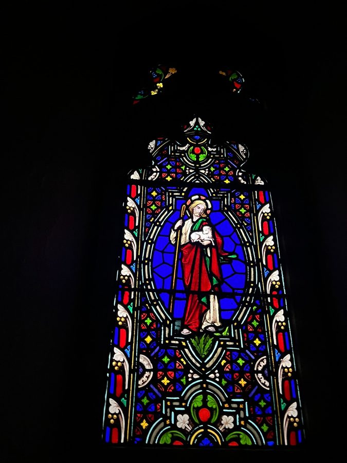 The monstrance on the altar with stained glass behind