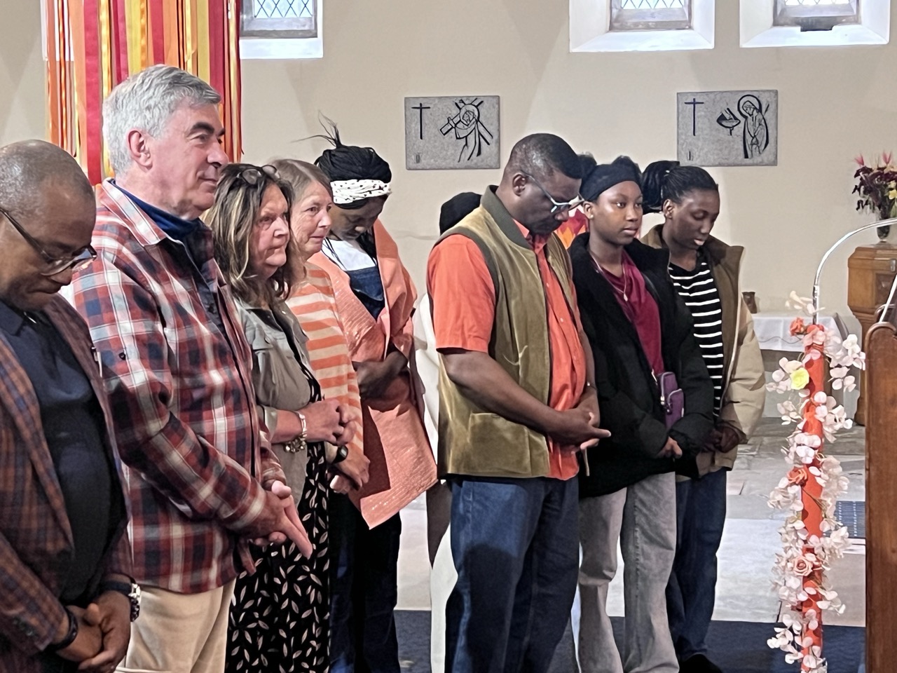 Parishioners standing in prayer at the lectern